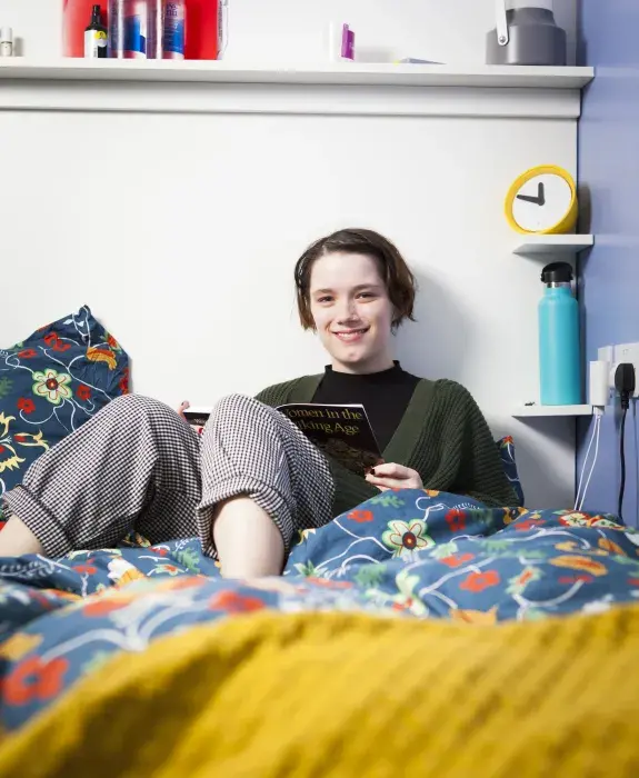 Student reading in bedroom. 